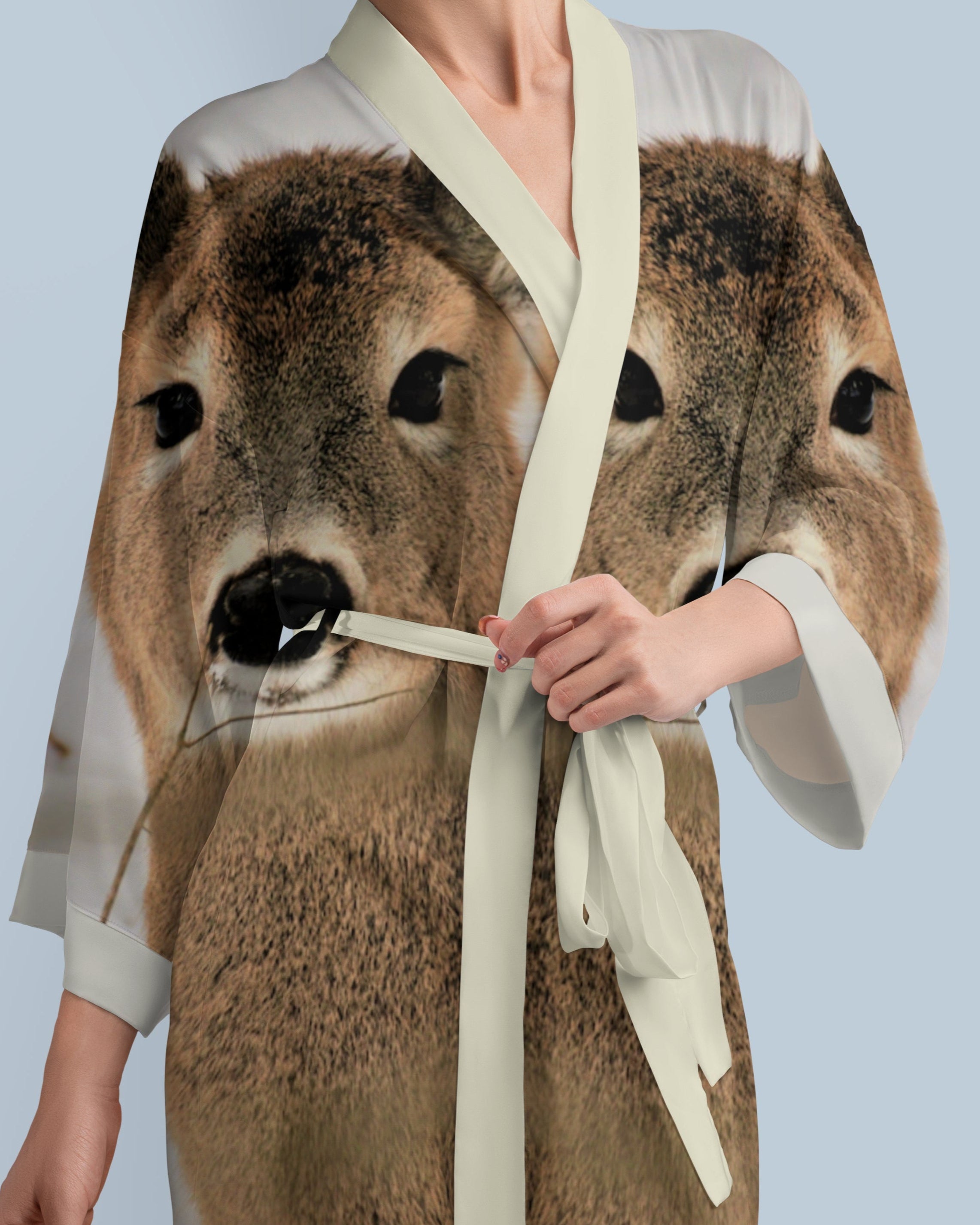 Person wearing a kimono with a deer design on a light blue background