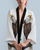 Person wearing a white kimono with eagle design on a light blue background