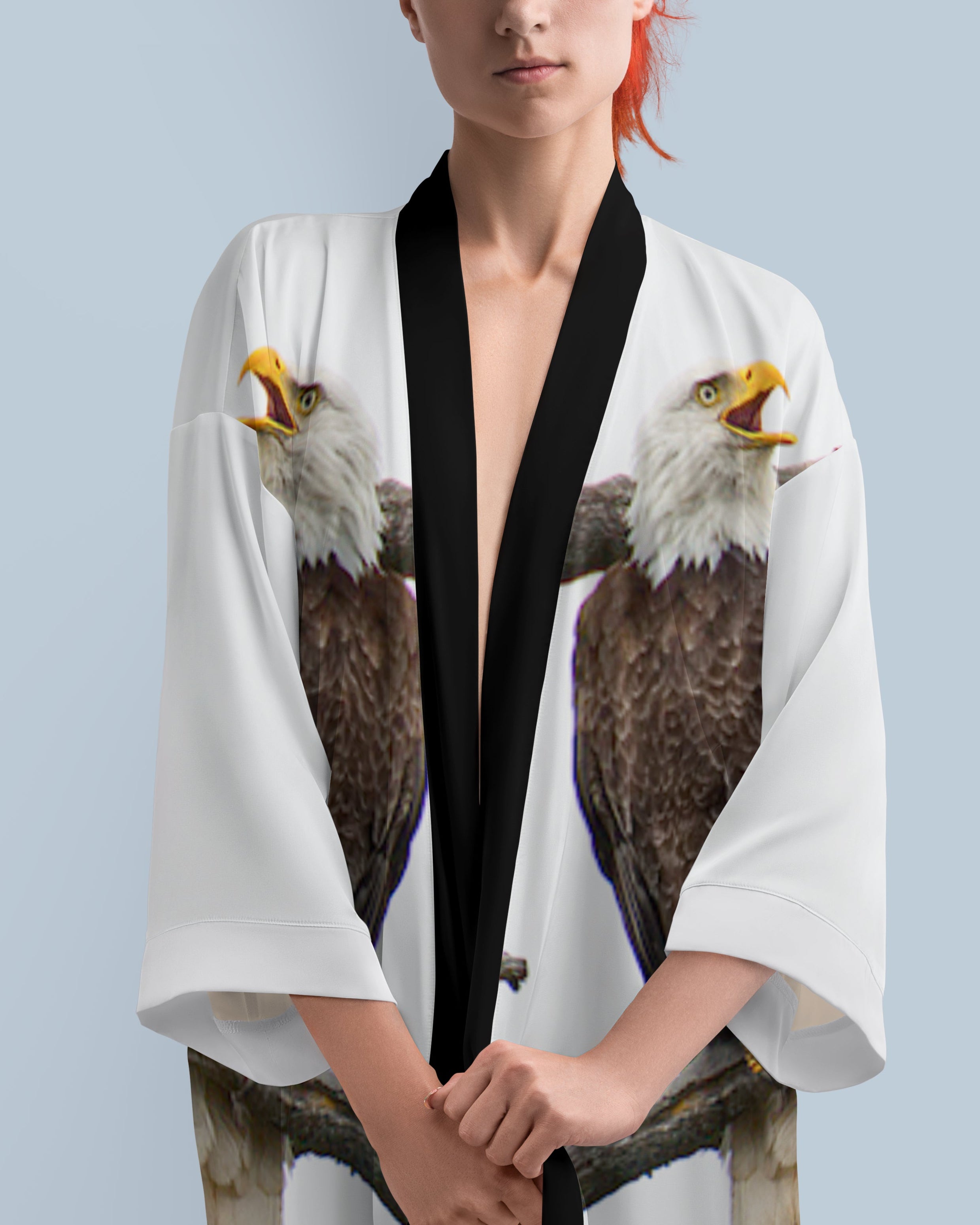 Person wearing a white kimono with eagle design on a light blue background