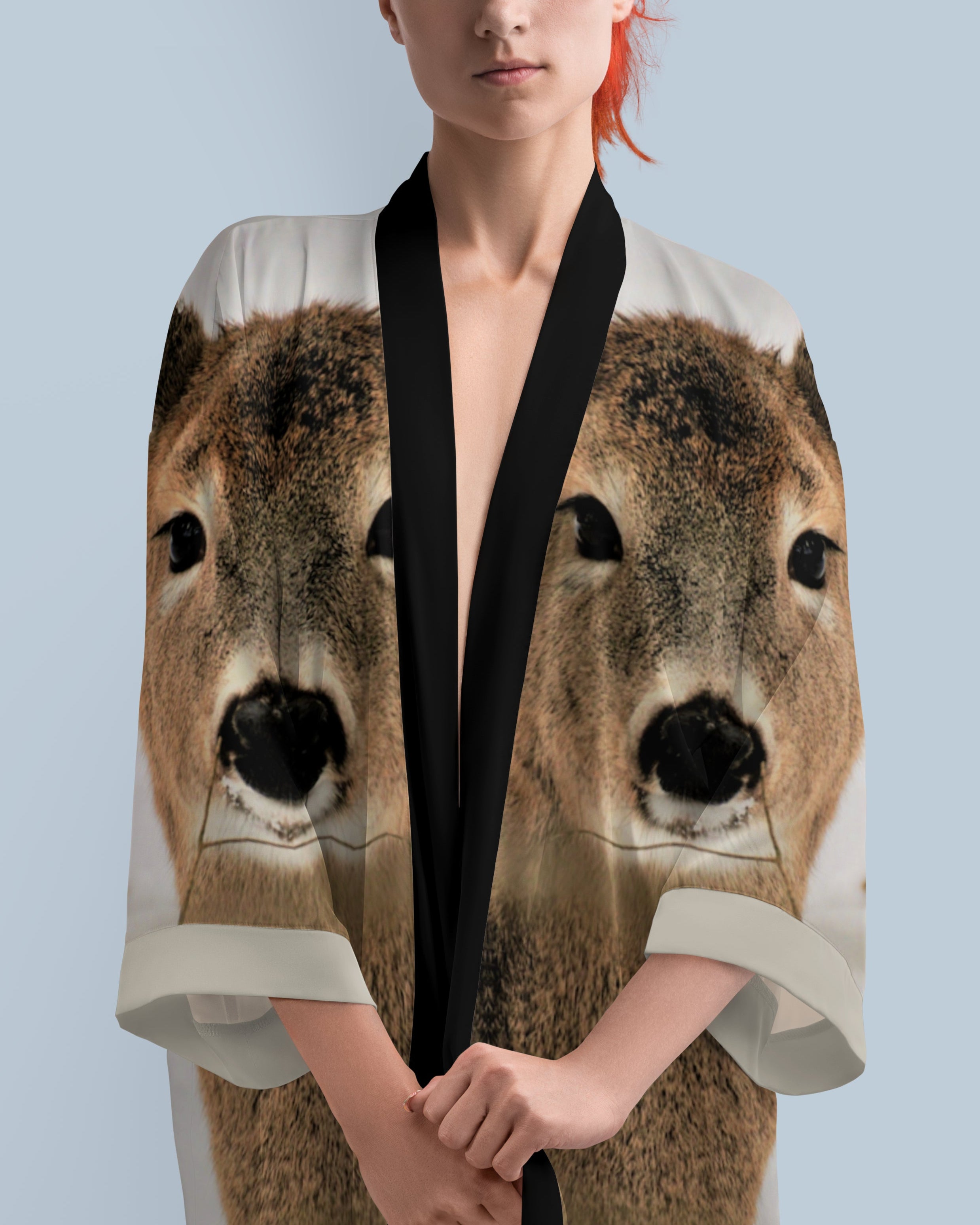 Woman wearing a kimono-style garment with deer face print on a light blue background