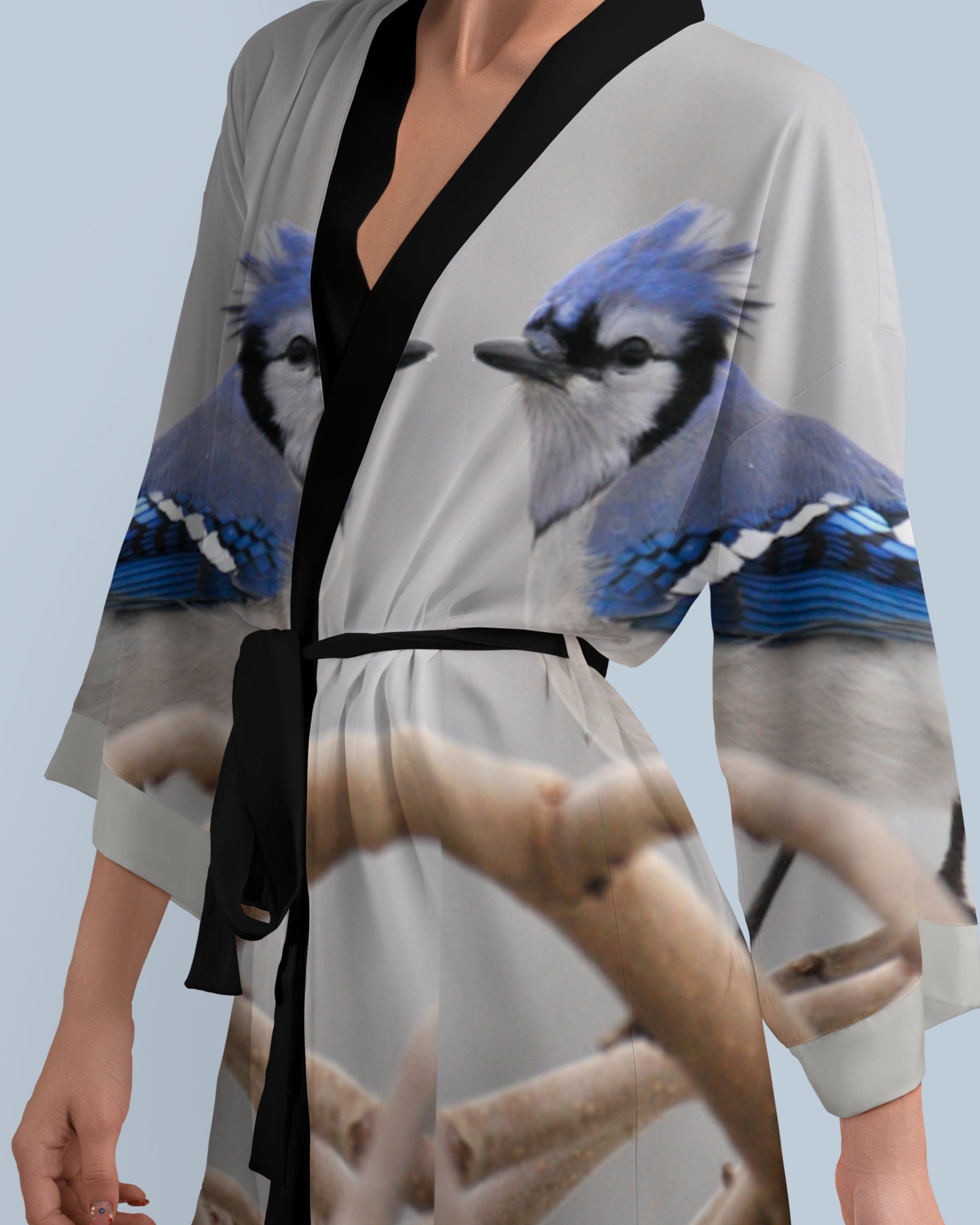 Woman wearing a kimono-style robe with blue jay bird design on a light blue background