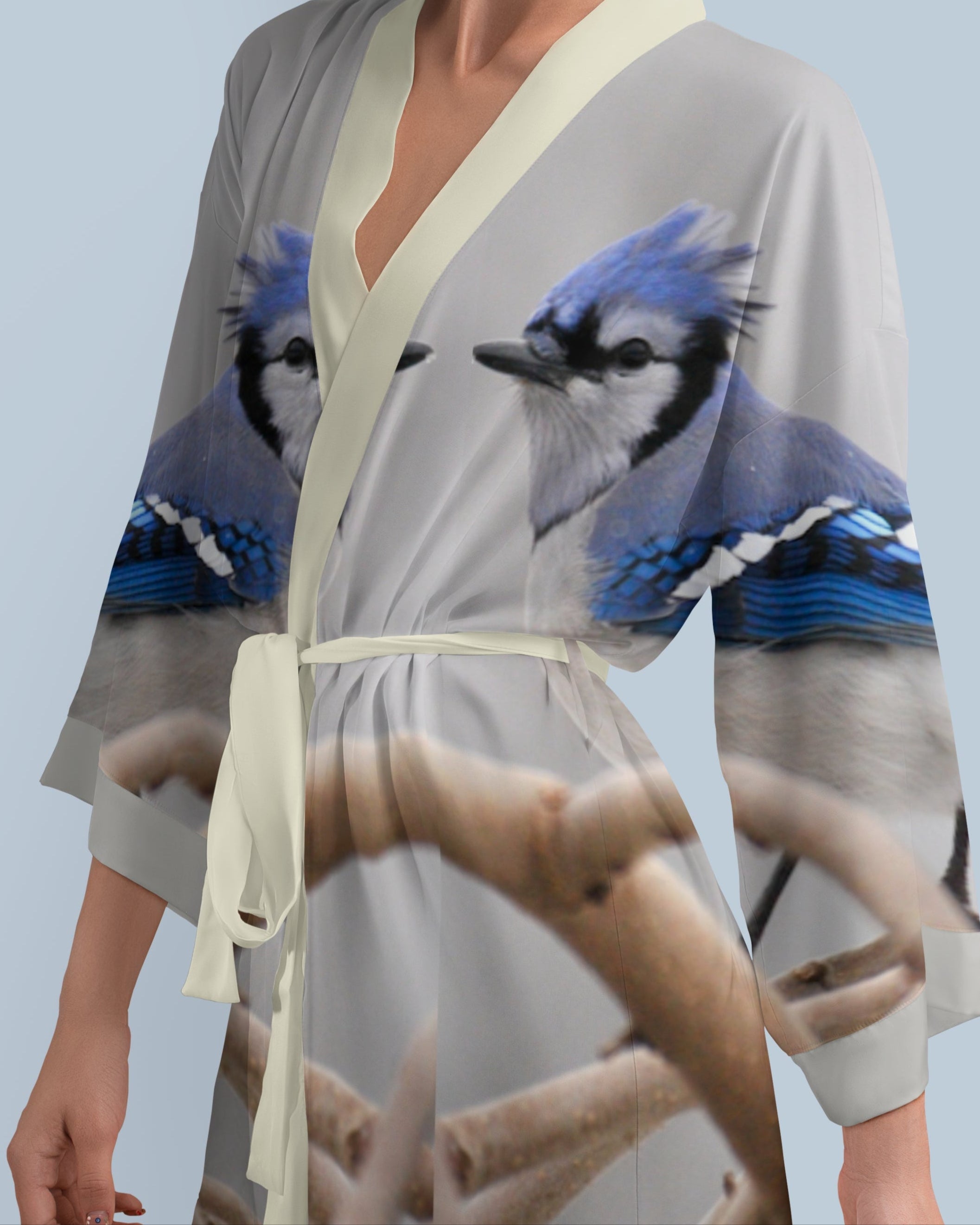 Woman wearing a kimono-style robe with blue jay bird design on a light gray background