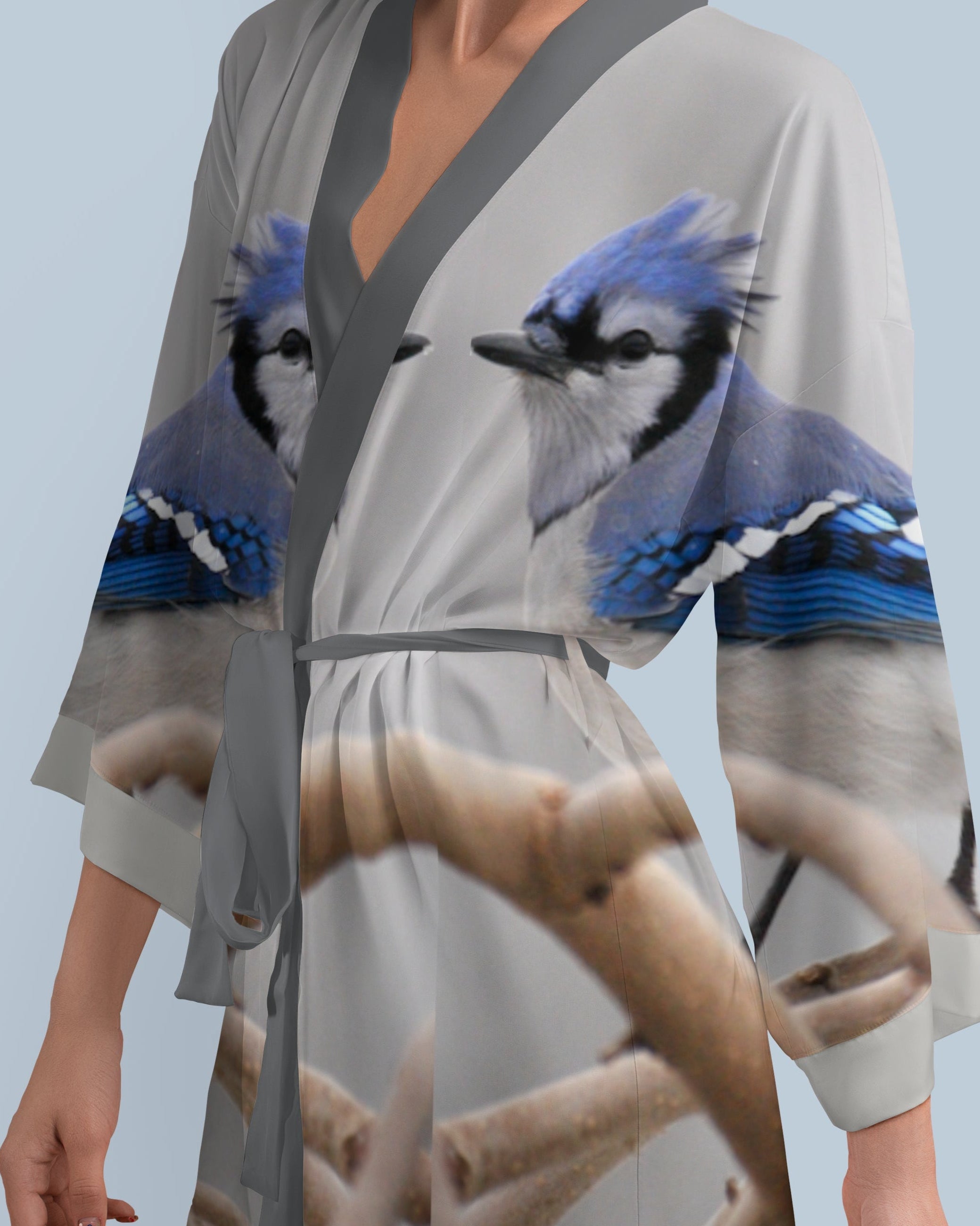 Woman wearing a kimono-style robe with blue jay bird design on a light blue background