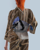 Person wearing a kimono with a blue jay bird design on a light blue background