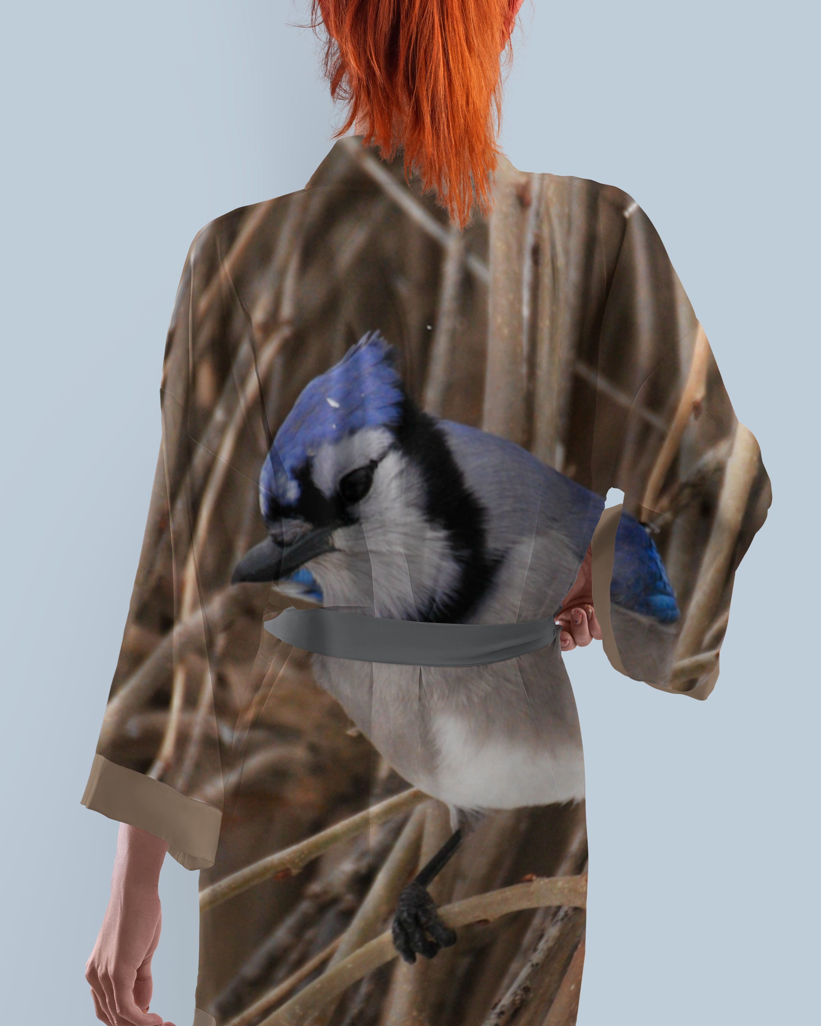 Person wearing a kimono with a blue jay bird design on a light blue background